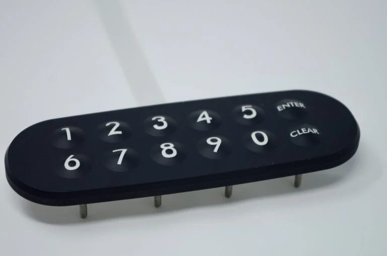 Clavier noir à touches numériques en relief, touches ENTER et CLEAR et goujons de fixation visibles