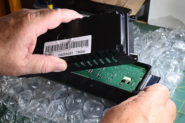 Opened automotive climate-control module showing its circuit board and rear housing