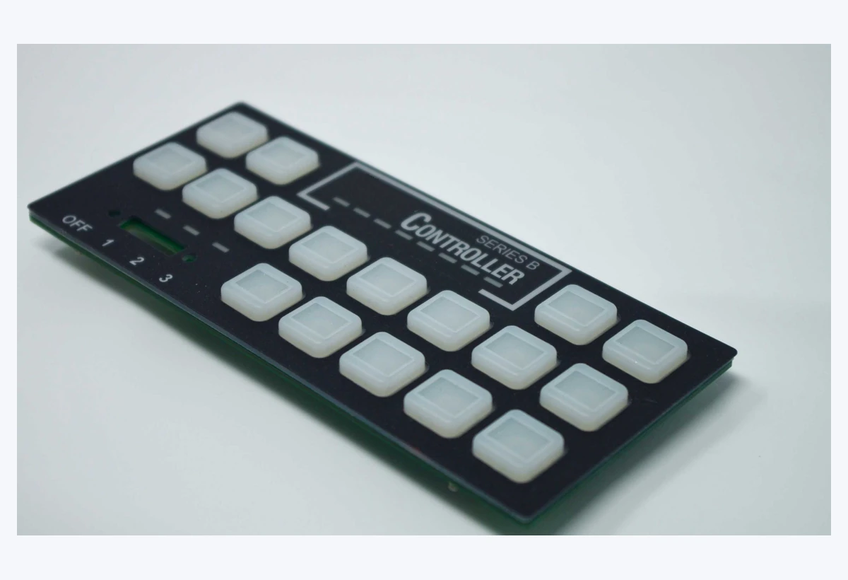 Completed control panel with white square keys, printed legends and a green circuit-board edge