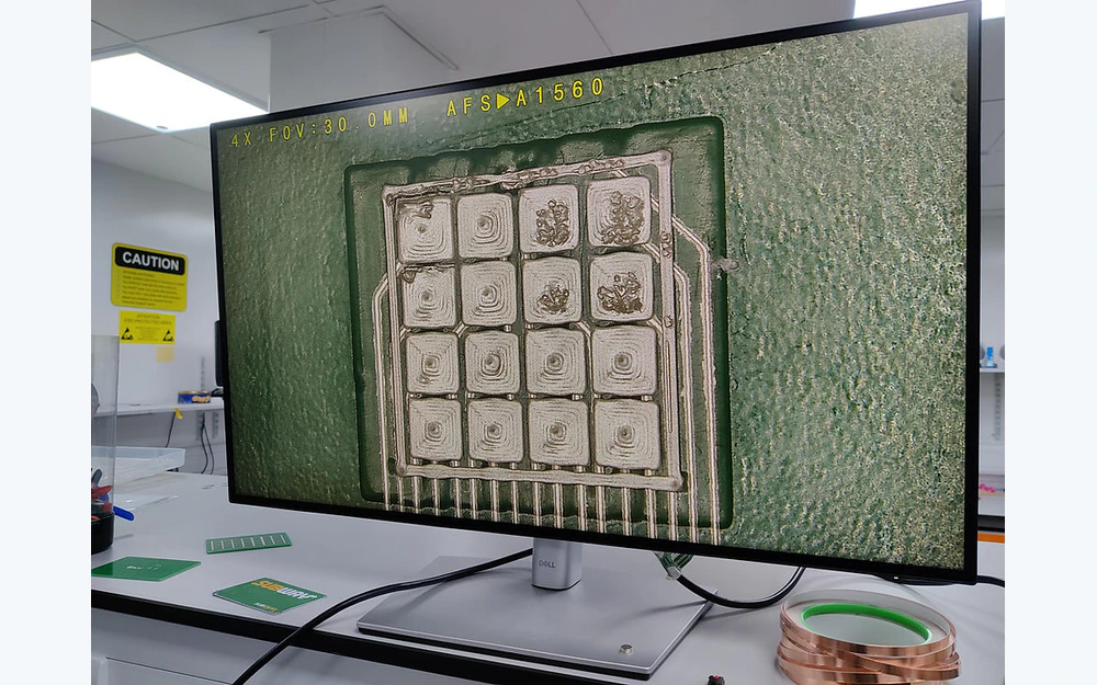 Magnified inspection view of a printed multi-pad electrode array on a laboratory monitor