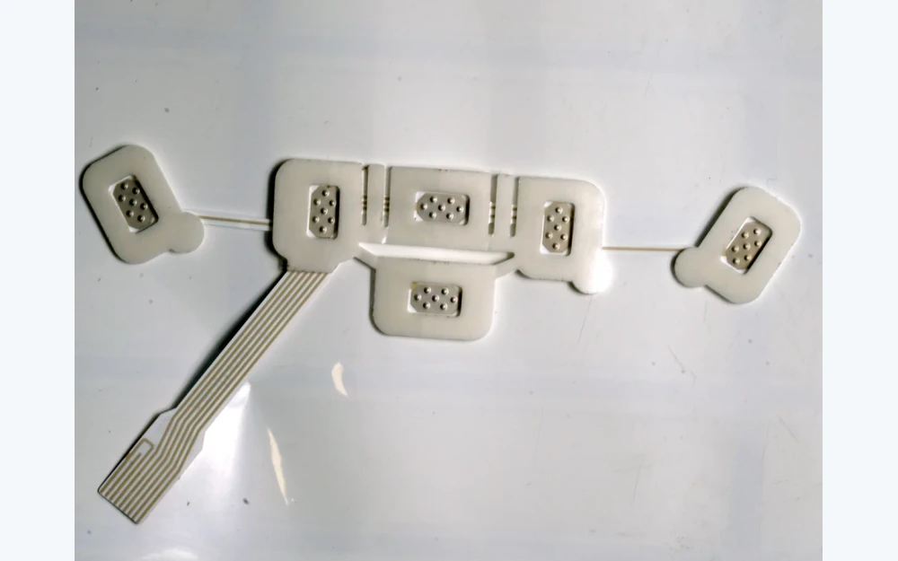 Six-contact flexible electrode array with visible channel traces and tail