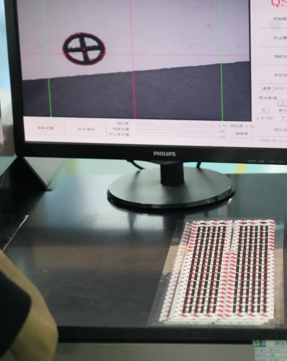 Optical inspection workstation showing a magnified registration mark on a monitor