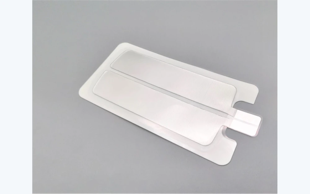 Split conductive zones and connector tab on an electrosurgical return pad