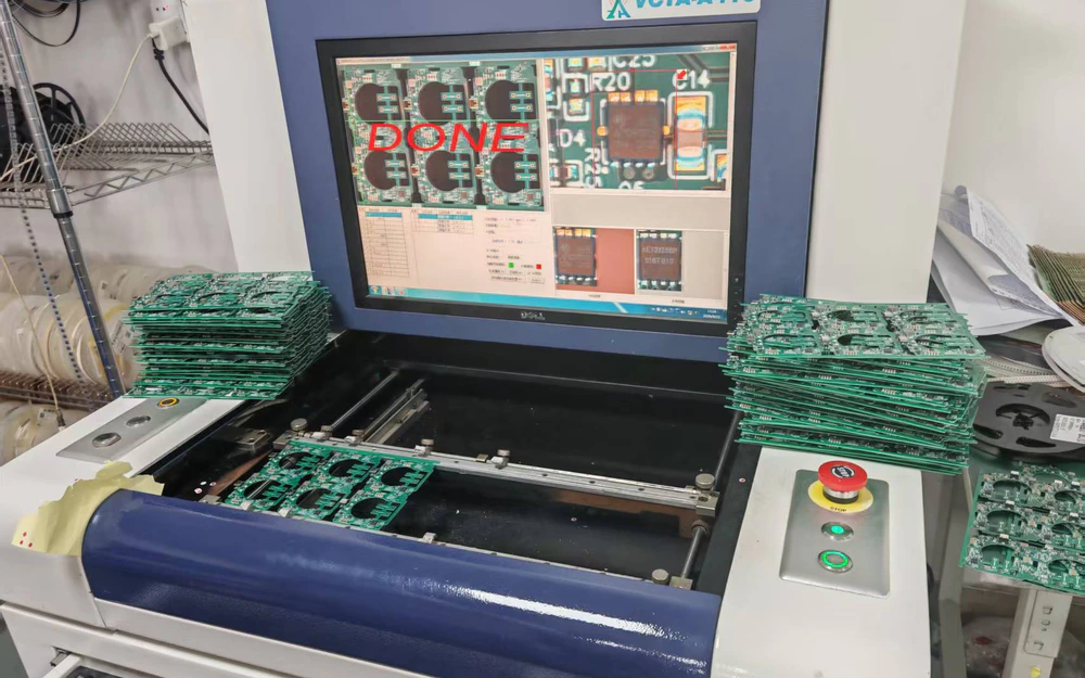 Real PCBA panels at an automated optical inspection station with inspection results on the screen
