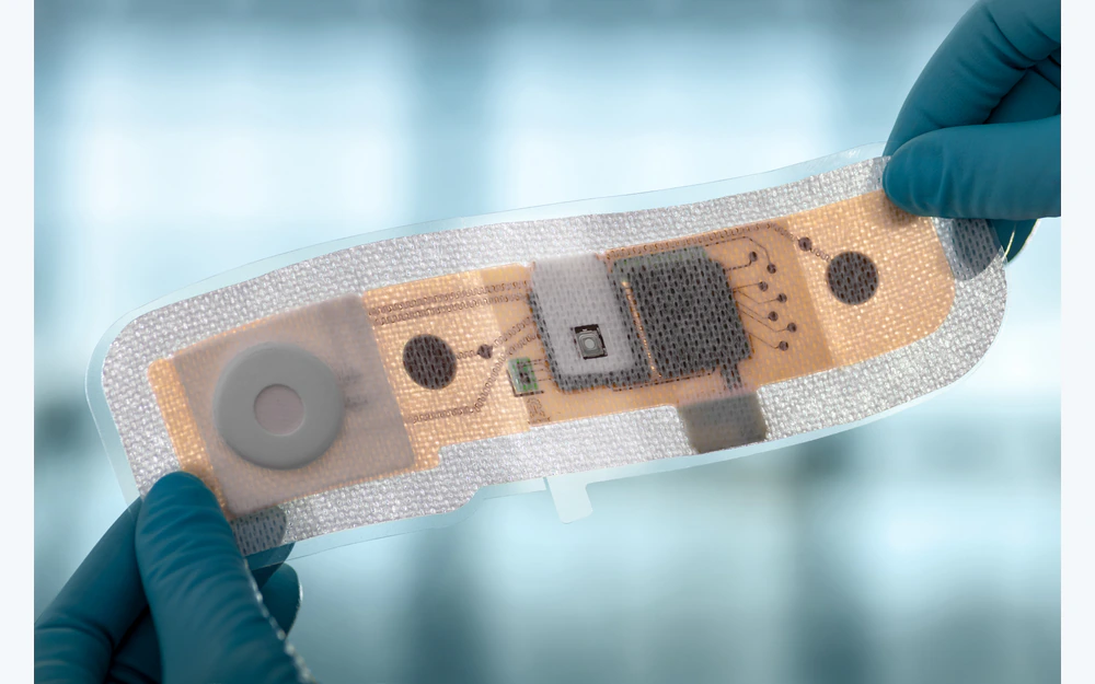 Integrated wearable ECG patch with textile backing, printed circuitry, and electronics held by gloved hands