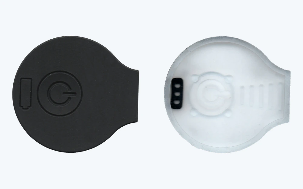 Front and rear views of a silicone power button showing the molded key and conductive contact