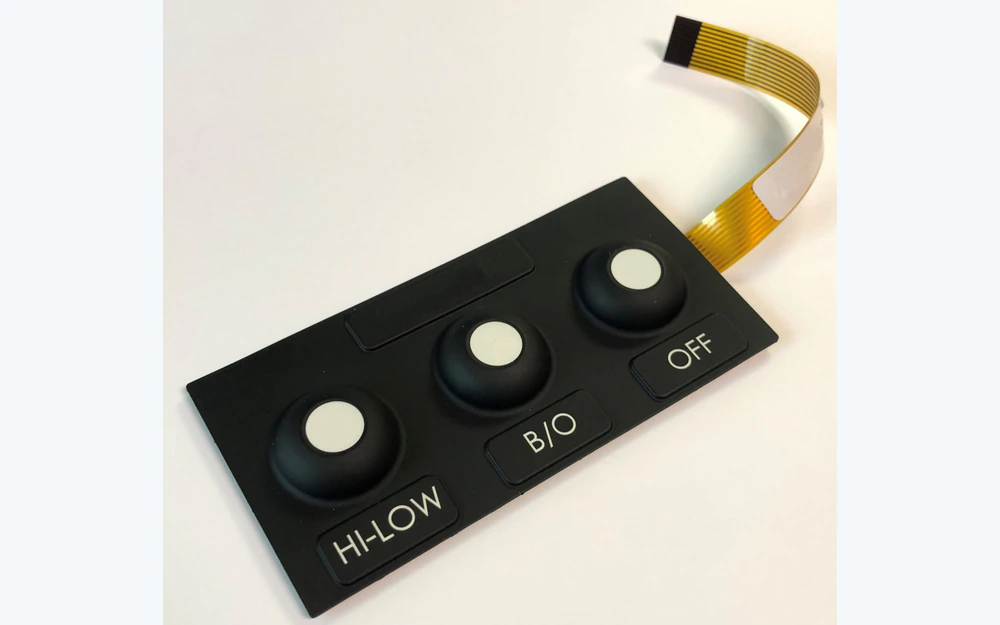 Black silicone keypad with three raised round keys and an attached flexible circuit tail