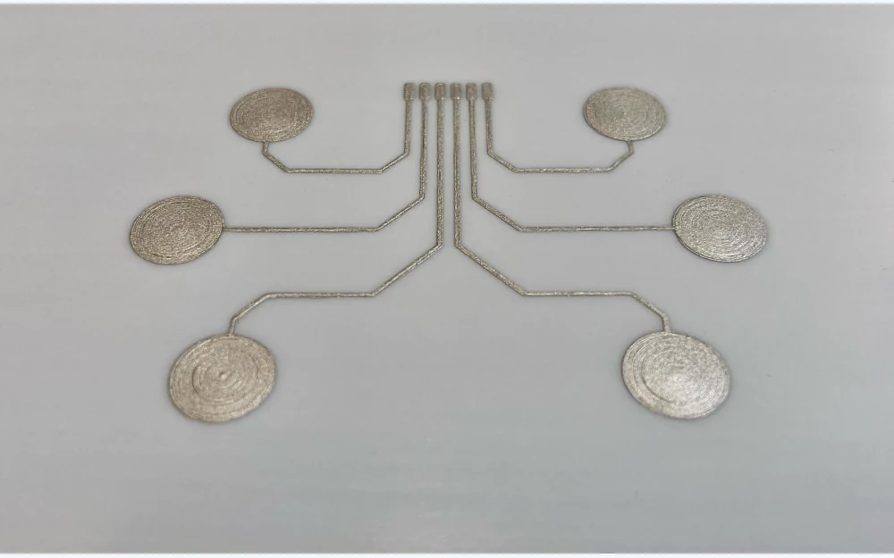 Six silver-colored printed electrode sites connected by fine traces
