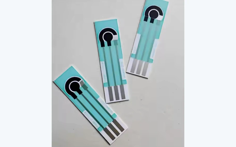 Three printed sensor strips with circular electrode contacts and terminal pads