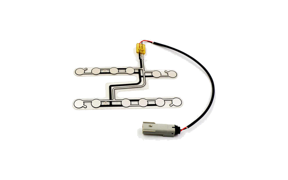 Printed car seat occupancy sensor with two sensing strips, routed traces, cable, and connector