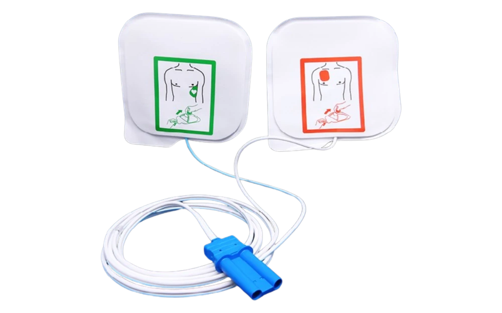 Fotografía de dos parches de desfibrilación con pictogramas de colocación, cables enrollados y conector azul