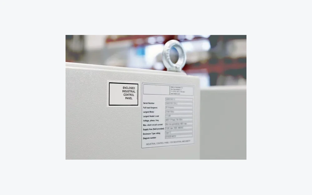 Printed equipment identification label applied to a textured industrial control enclosure
