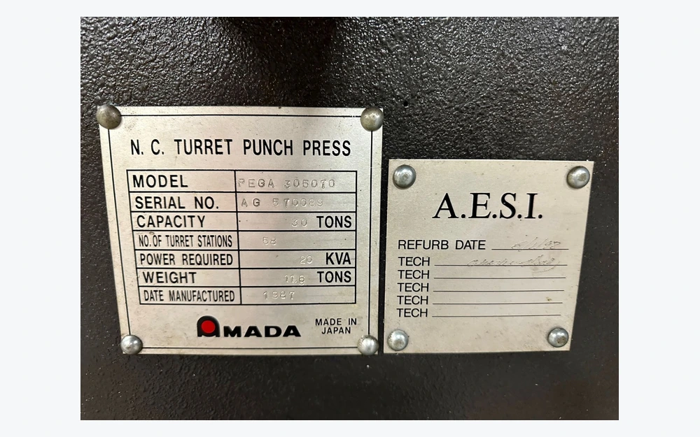Two metal equipment nameplates secured to a textured machine housing with corner fasteners