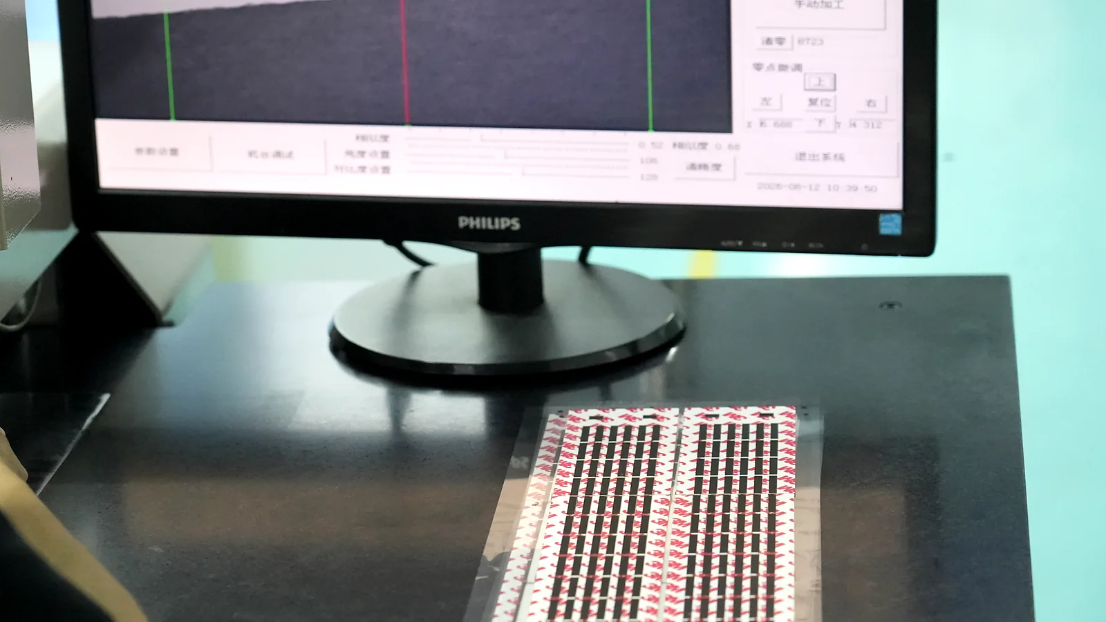 Optical inspection station checking printed feature registration before release