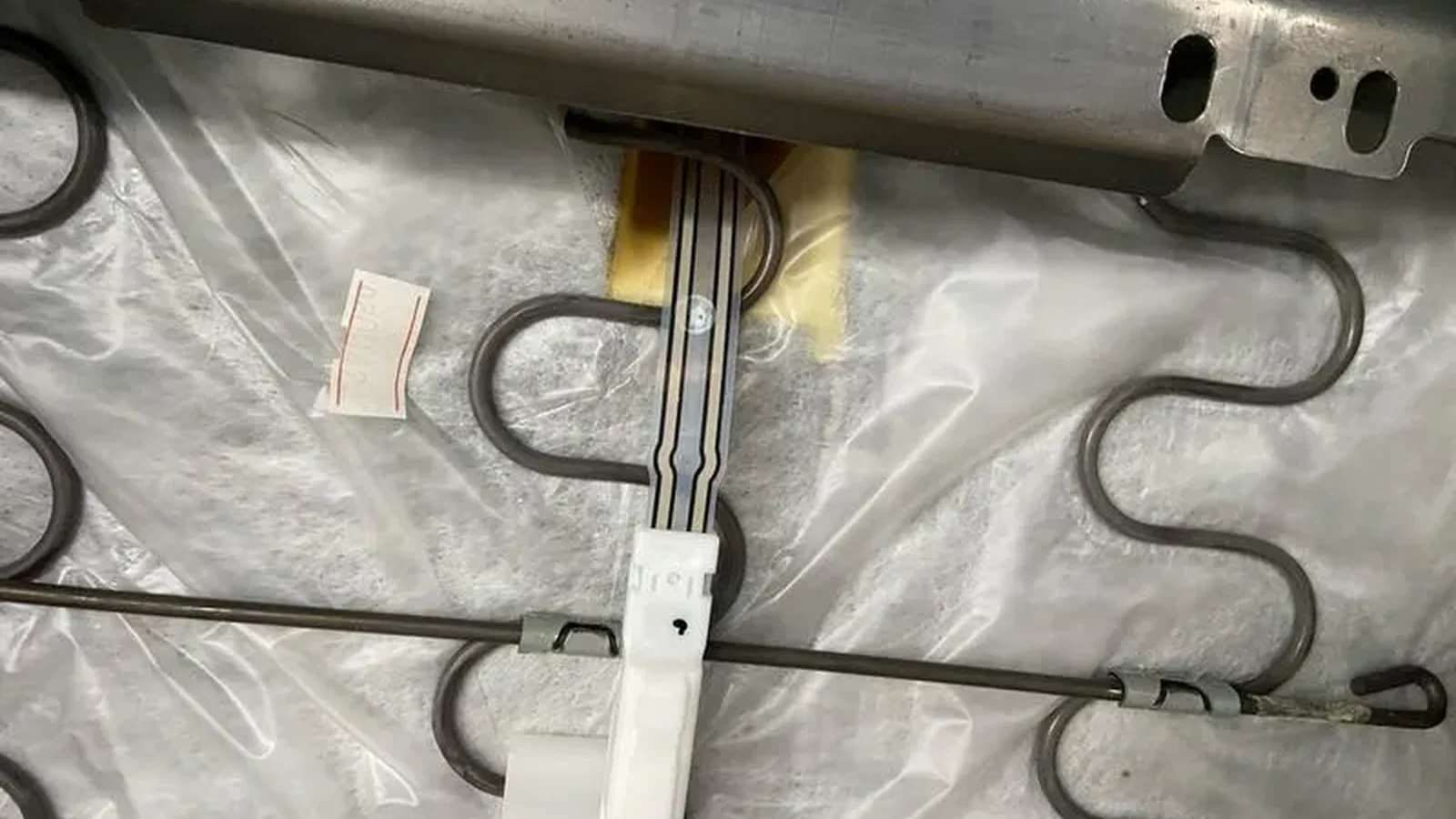 Seat pressure sensor tail installed beneath a production seat cushion