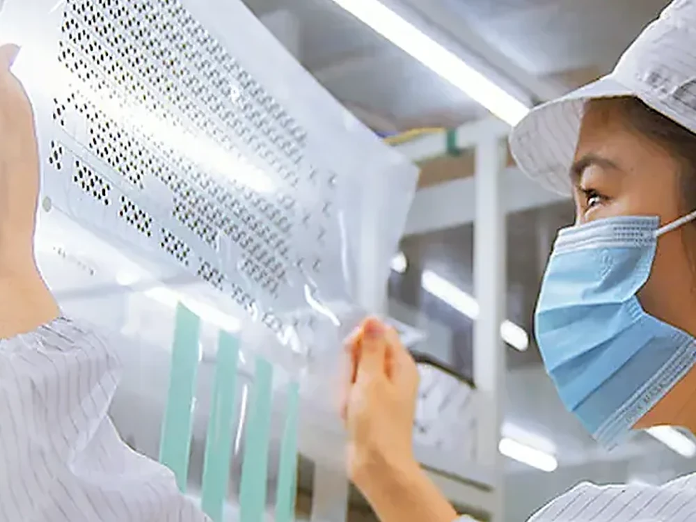 Opératrice JASPER inspectant des matériaux transformés pour claviers à membrane